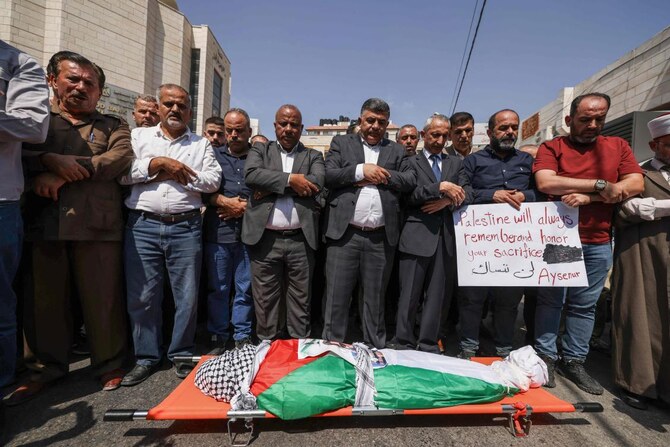 Palestinians pray by the body of slain Turkish-American International Solidarity Movement activist Aysenur Ezgi Eygi.