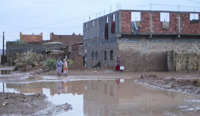 Women walk past floods caused by heavy rainfall in Tagounite, Zagora, southern Morocco, Saturday, Sept. 7, 2024. (AP)