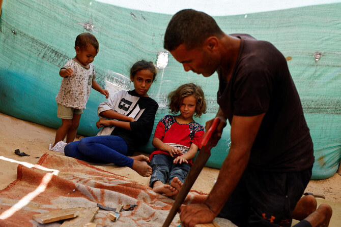 Gaza carpenter crafts wooden sandals for daughters as war rages