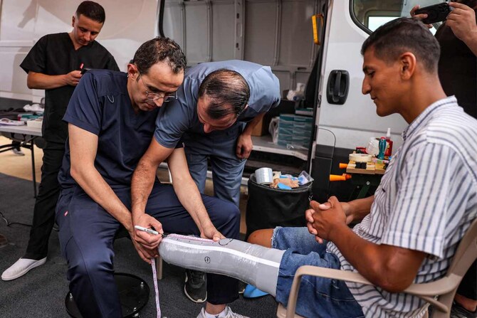 A man with an above-the-knee amputation is fitted with a new prosthetic limb at a Jordanian field hospital in Khan Yunis.