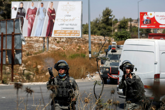 Israeli border guards fire their weapons as Palestinians protest near Beit El in the occupied West Bank on August 17, 2021. (REUTERS/Mohamad Torokman)