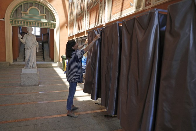A town hall employee sets voting booths in preparation of the upcoming French legislative elections (File/AFP)