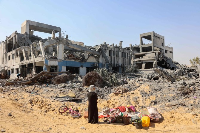 A woman looks around as she salvages items at the damaged UNRWA building in Gaza. (AFP)