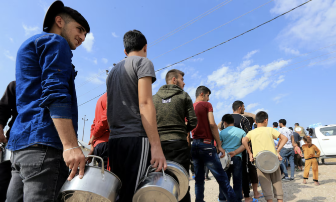 Syrian displaced families stand in queue to get their food. (Reuters/File Photo)