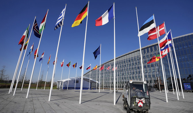 An empty flagpole stands between the national flags of France and Estonia outside NATO headquarters in Brussels. (AP file photo)