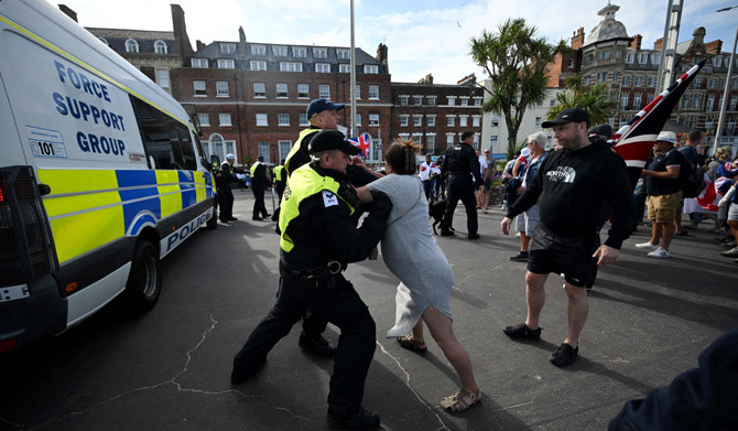 Police officers restrain a protester in Weymouth, on the southwest coast of England. (AFP)