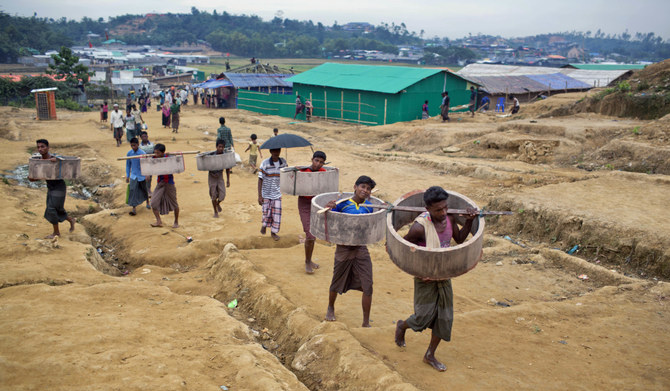 Rohingya Muslims carrying construction material walk towards to a refugee camp in Bangladesh, Friday, Nov. 17, 2017. (AP)