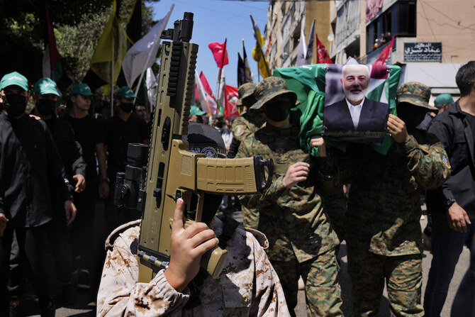 Boy holds toy machine gun, as Hamas fighters, right, carry mock coffin of Hamas political chief Ismail Haniyeh. (AP)