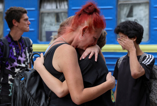 A woman embraces her relatives before they board an evacuation train to Western Ukraine. (Reuters)