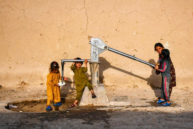 Afghan girls fetch drinking water from a handpump on the outskirts of Mazar-i-Sharif. (AFP)