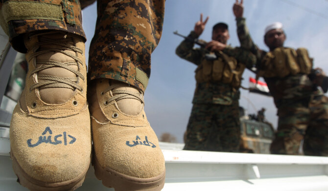 A member of the Iraqi paramilitary Popular Mobilisation units with "Daesh" written on his boots in Tikrit. (AFP)